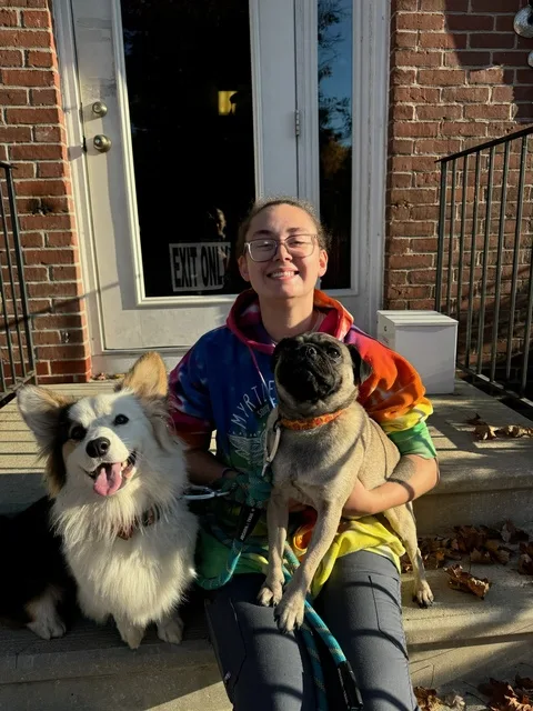 Kim B. sitting outside with two dogs