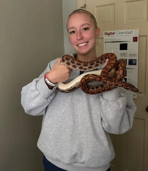 Maddy with a corn snake draped over her shoulders